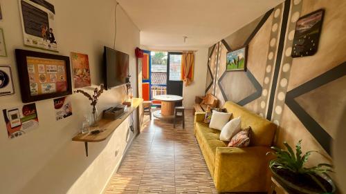 a living room with a yellow couch and a tv at La Marteja in Salento