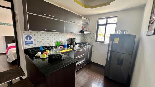 a small kitchen with a refrigerator and a sink at La Marteja in Salento