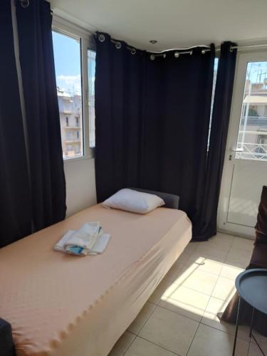 a bed in a room with black curtains and a window at Acharnon Private Room in Athens