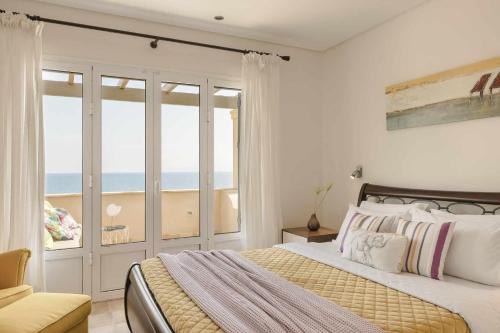 a bedroom with a bed with a view of the ocean at Villa Eternity, Ai Helis Kefalonia in Kefallonia