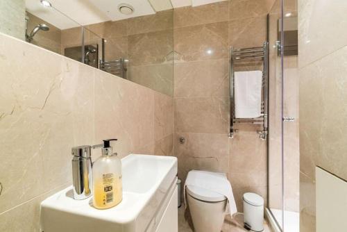 y baño con lavabo, aseo y ducha. en 2 bed arty flat at Trafalgar Square, en Londres