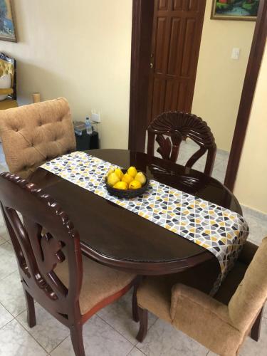 una mesa de comedor con un bol de fruta. en Clásico apartamento en Santo Domingo Este, en El Seis