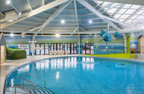 a large swimming pool in a building at Caravan sleeps 8 at Littlesea, Weymouth in Wyke Regis