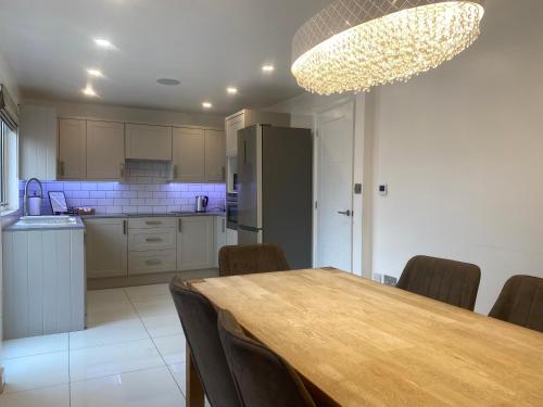 a kitchen with a table and chairs and a refrigerator at 3 Bedroom House in Northampton