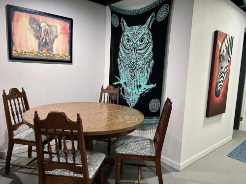 a dining room table with chairs and an owl picture on the wall at The Treasure House in Smyrna