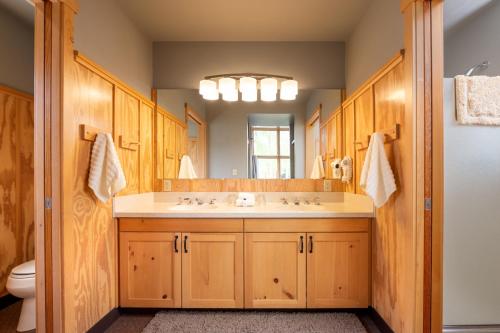 uma casa de banho com um lavatório e um espelho grande em Sleeping Lady Mountain Resort em Leavenworth