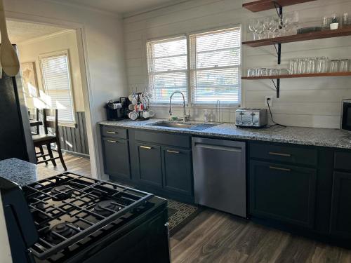 a kitchen with black cabinets and a stove top oven at The Treasure House in Smyrna