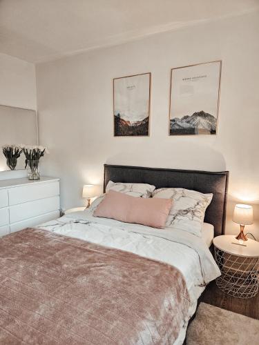 een slaapkamer met een bed en twee foto's aan de muur bij Modernes Appartment im Grünen in Witten