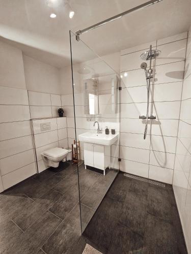 a bathroom with a shower and a sink and a toilet at Modernes Appartment im Grünen in Witten