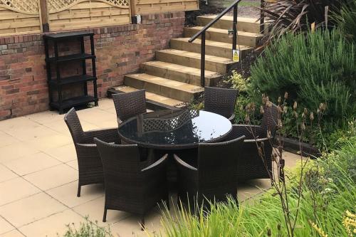 a patio with a table and chairs and stairs at The Cottage, with Superking bed & private patio in Chaddesley Corbett