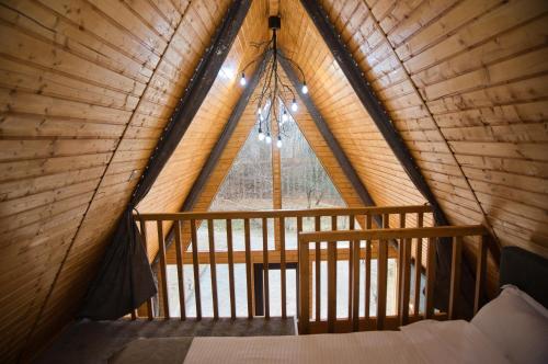 a bedroom in a tree house with a large window at Cabana AFrame Olanesti in Băile Olăneşti