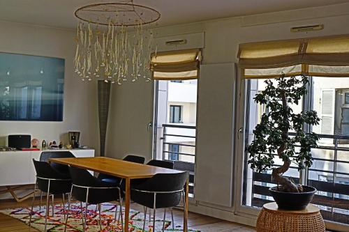 une salle à manger avec une table et un pot dans l'établissement Triplex de luxe 200m2, 5 ch/10-12 personnes., à Boulogne-Billancourt