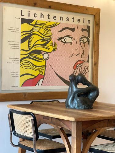 a table with a statue on it with a poster at Biennale Apartment Venice in Venice