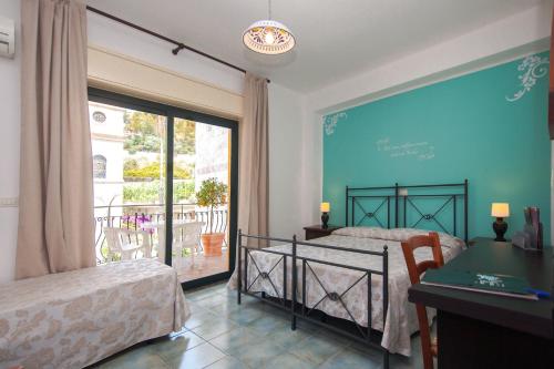 um quarto com 2 camas e uma grande janela em Hotel Donna Rosa em SantʼAlessio Siculo