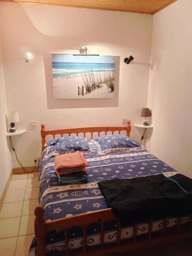 une chambre avec un lit et un tableau au mur dans l'établissement Locabrem 1, à Brem-sur-Mer