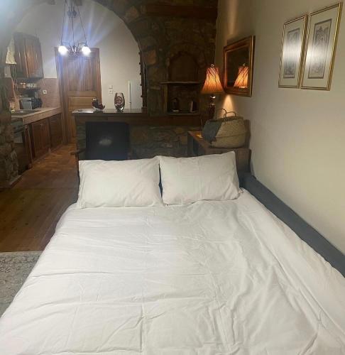 a large white bed sitting in a room at Urban River House in Florina