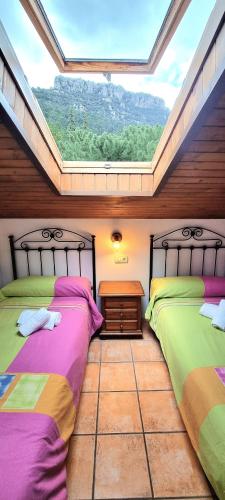 two beds in a room with a large window at Brisa de Utrero in Arroyo Frio