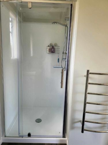 a shower with a glass door in a bathroom at Hillview in Waimate