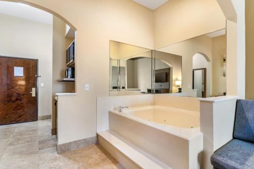 uma ampla casa de banho com uma banheira e uma cadeira. em Comfort Suites Bush Intercontinental Airport em Houston