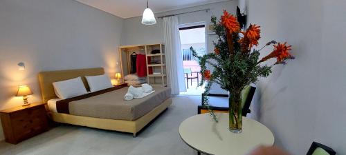 a bedroom with a bed and a vase of flowers on a table at Avista apartments in Lygia