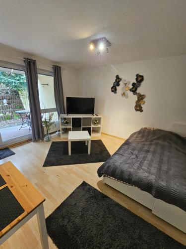 1 dormitorio con 1 cama, TV y mesa en Ulmer Nestchen, en Ulm