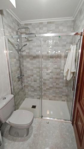 a bathroom with a shower with a toilet and a sink at Piso Areal con vistas al mar in Portonovo