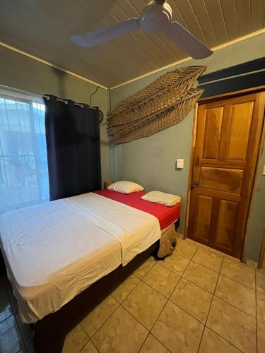 sypialnia z łóżkiem i drewnianymi drzwiami w obiekcie Surf House w mieście Sámara