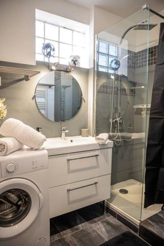 une salle de bain avec une machine à laver et un lavabo dans l'établissement Le Saphir Proche Plage Catalans, à Marseille