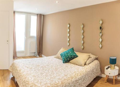 une chambre avec un lit avec un oreiller bleu dessus dans l'établissement Le Saphir Proche Plage Catalans, à Marseille