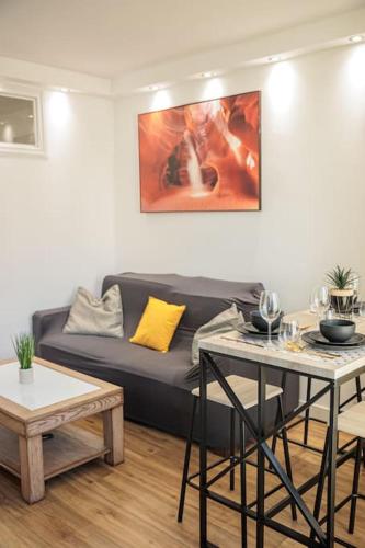 un salon avec un canapé et deux tables dans l'établissement Le Saphir Proche Plage Catalans, à Marseille