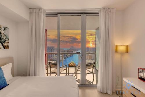 1 dormitorio con 1 cama y balcón con vistas. en Amenities BALCONY w Stunning Views-Beachfront, en Hallandale Beach