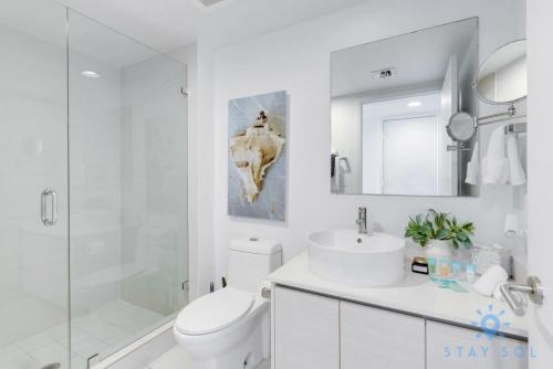 a bathroom with a toilet and a sink and a shower at Amenities BALCONY w Stunning Views-Beachfront in Hallandale Beach