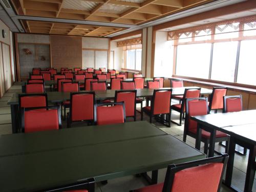 an empty room with tables and red chairs at Chisun Grand Nagano in Nagano