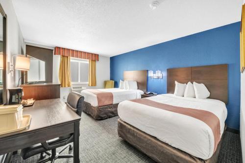 a hotel room with two beds and a desk at City Center Inn in Newport News