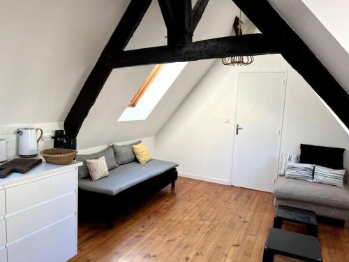 - un salon mansardé avec un canapé dans l'établissement Charmant T4 entièrement rénové !, à Lannion