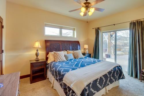 a bedroom with a bed with a blue comforter and a window at Cozy Ridgway Vacation Rental Hike, Ski and Explore! in Ridgway