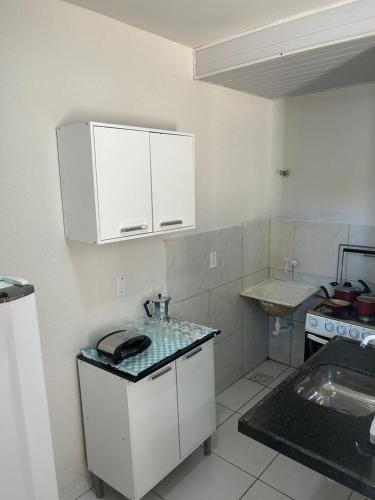 cocina con armarios blancos y encimera en Apartamento Grand Maracanaú - Premium, en Maracanaú