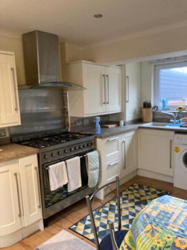 eine Küche mit weißen Schränken und einem Herd mit Backofen in der Unterkunft Broxbourne Two-Bedroom Apartment Close To Amenities in Hoddesdon