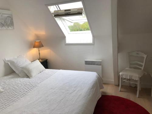 1 dormitorio con cama blanca y ventana en La clé des Champs en Saint-Josse