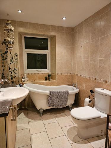 uma casa de banho com uma banheira, um WC e um lavatório. em The Arches em Brough
