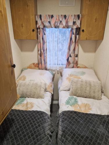 two beds in a small room with a window at U EGONA in Wejsuny