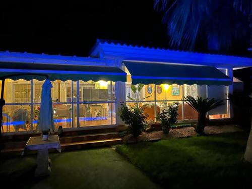Chalet La Calma en Lorca في لوركا: منزل أمامه مظلة مغلقة في الليل