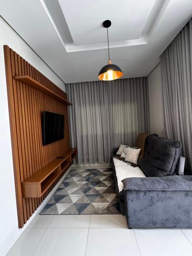 a living room with a couch and a flat screen tv at Casa Impecável in Palmas