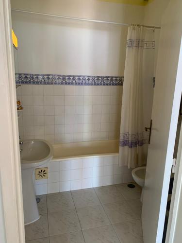 a bathroom with a tub and a sink and a toilet at Anabela Apartment in Carvoeiro