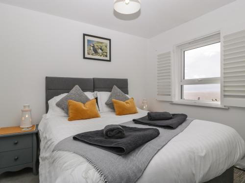 a bedroom with a bed with towels on it at Tŷ Glas in Bridgend