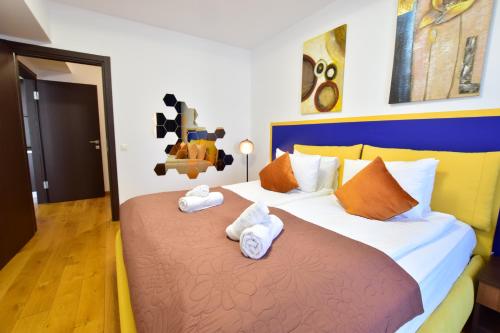 ein Schlafzimmer mit einem großen Bett mit Handtüchern darauf in der Unterkunft Upground Residence Apartments in Bukarest