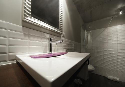 a bathroom with a sink with a purple counter top at Altes Stahlwerk Business & Lifestyle Hotel in Neumünster