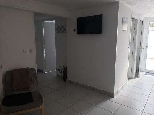 een woonkamer met een televisie aan de muur bij Appartement T3 3 étoiles à 4 km de la plage in Tarnos