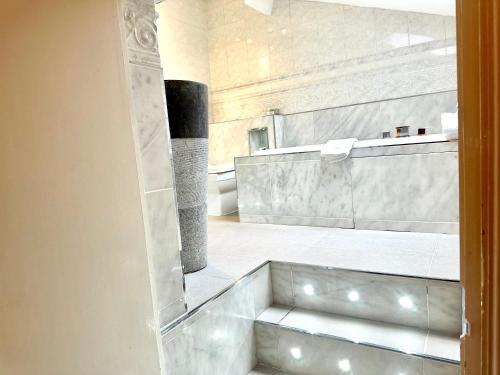uma casa de banho com uma cabina de duche ao nível do chão ao lado de uma escada em Munstone House em Hereford