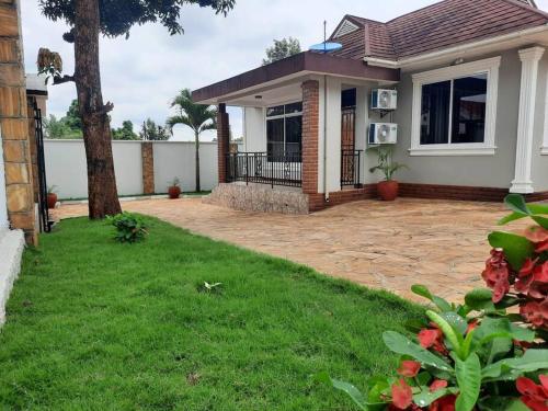 a house with a patio and a yard at Ellyz Home Stay in Moshi
